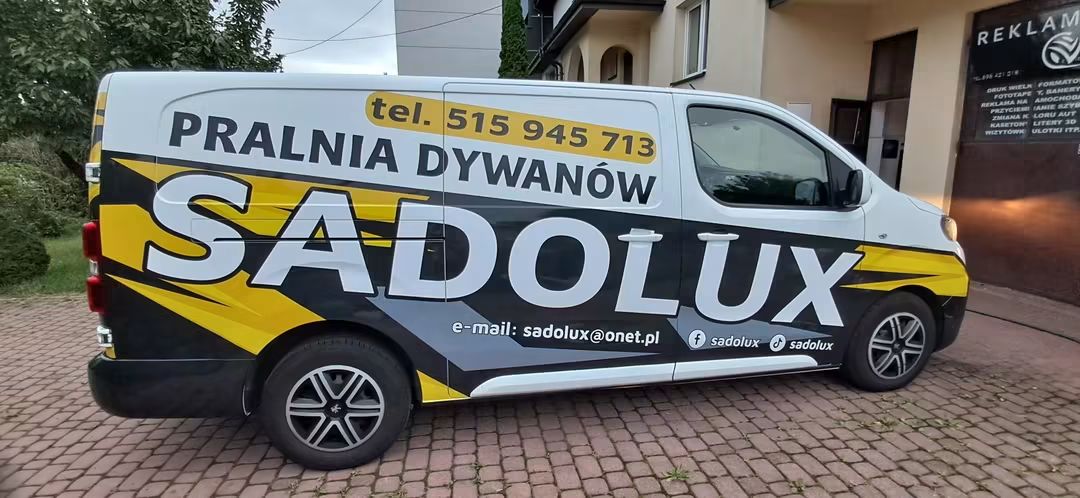 Firmowy bus SADOLUX z napisem Pralnia dywanów i numerem telefonu 515 945 713